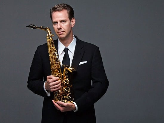 Timothy Mcallister holding an Alto Saxopone